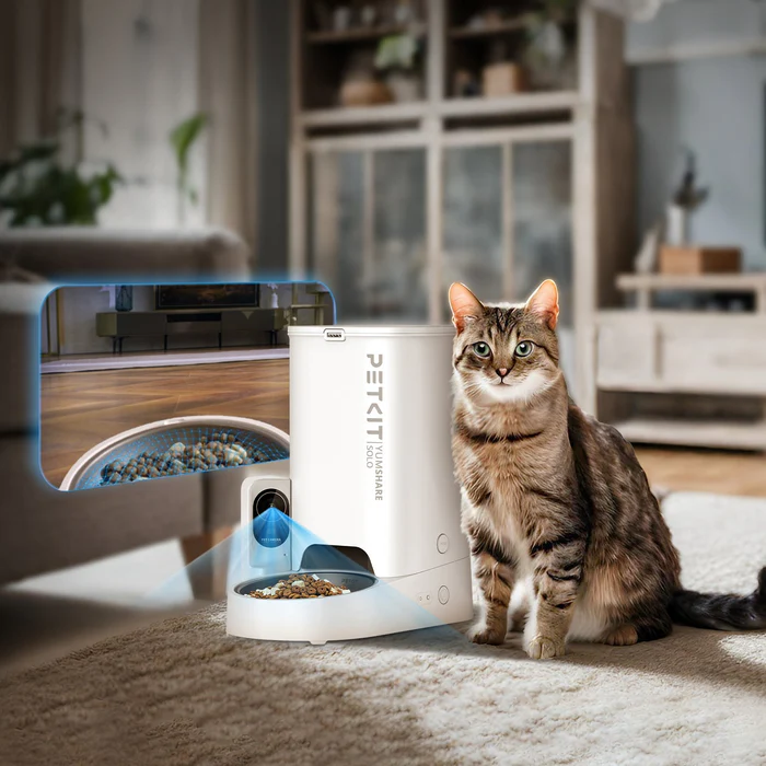 Gatto vicino a un distributore automatico di cibo bianco per animali domestici. Viene mostrata l'immagine del funzionamento interno.