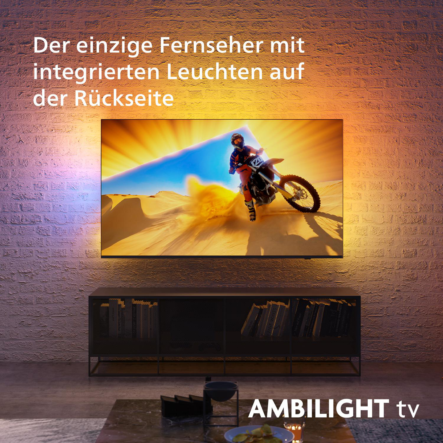 Ambilight-TV mit einem Motocross-Fahrer vor Backsteinmauerhintergrund.