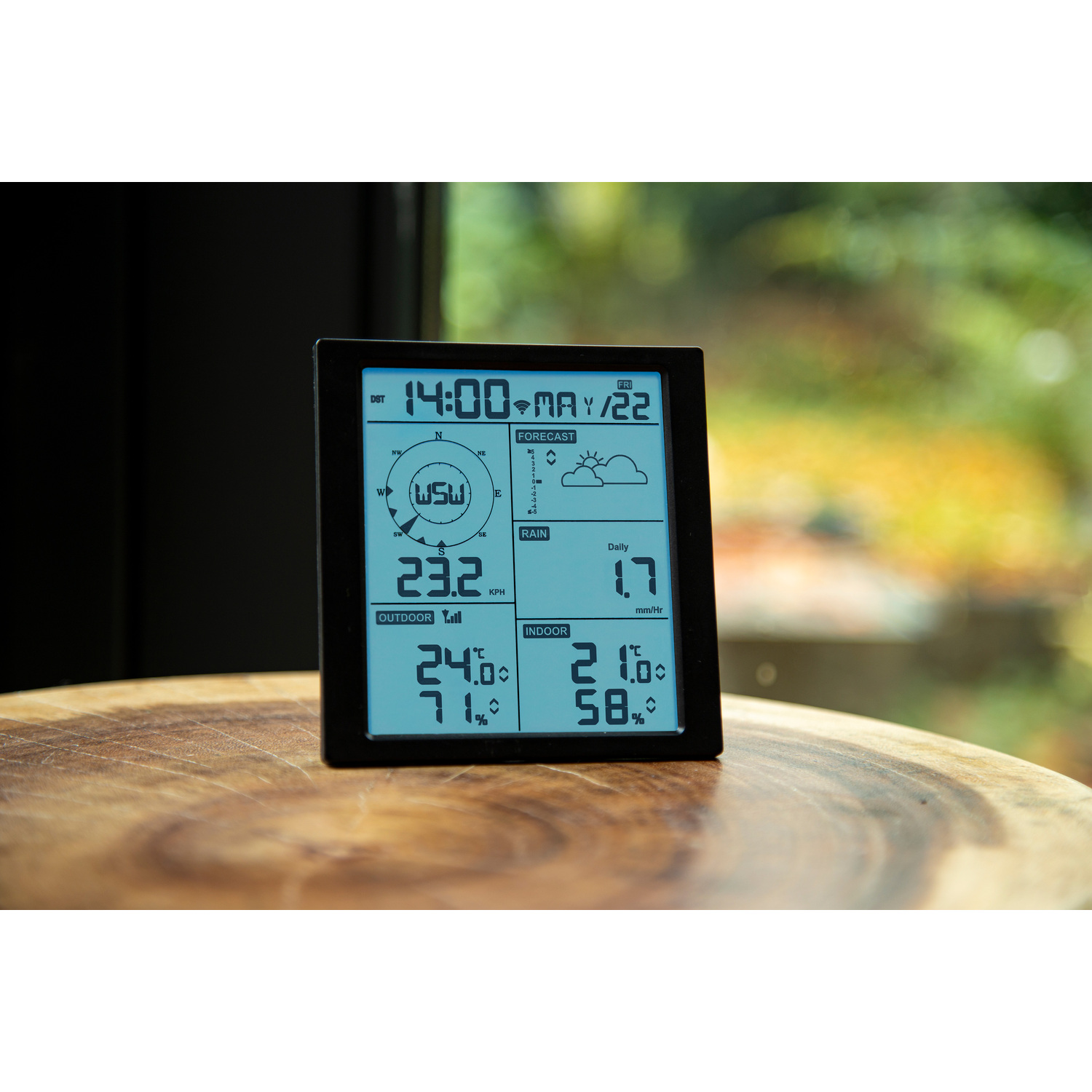 Weather station displaying date, time, forecast, outdoor and indoor temperature, and humidity.