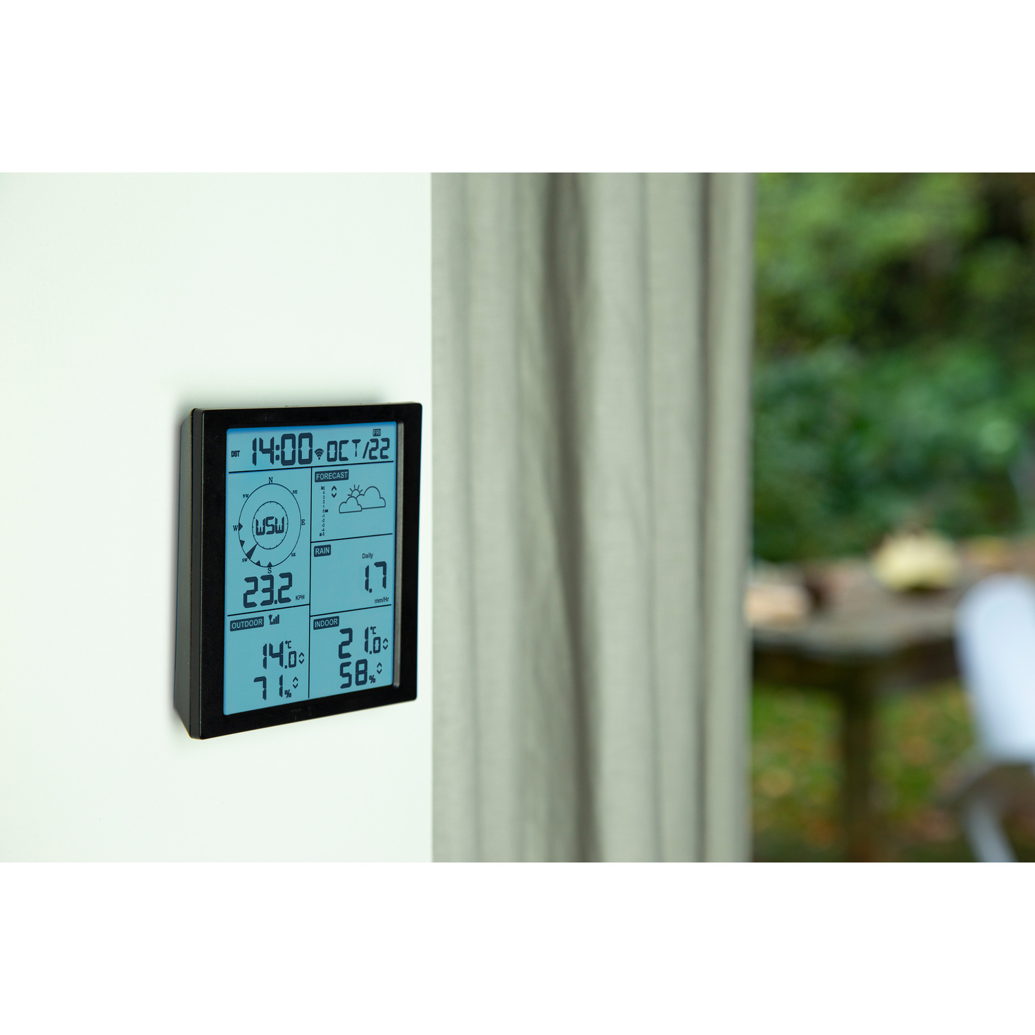 Weather station on wall, shows weather information, outdoor background.