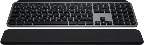 Felülnézet egy szürke Logitech billentyűzetről fekete csuklótámasszal, zöld felületen.