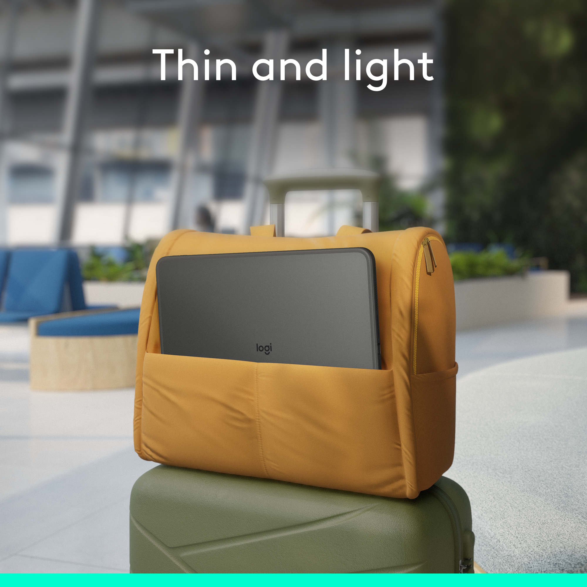 Ein schwarzes Tablet in einem gelben Rucksack, der auf einem grünen Koffer sitzt.