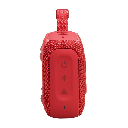 Güç, Bluetooth ve ses düğmeleri olan kırmızı bir taşınabilir hoparlör. Kumaş bir örgüye sahip.