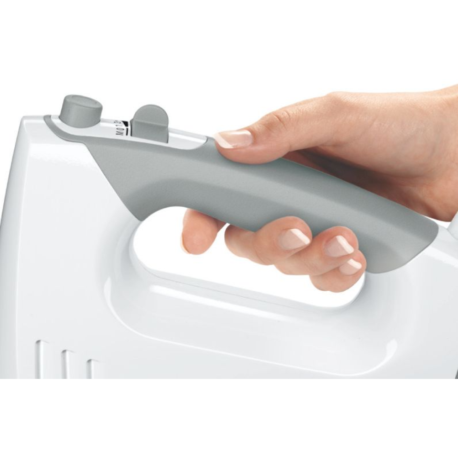 A hand holding the handle of a white hand mixer with a gray speed control.