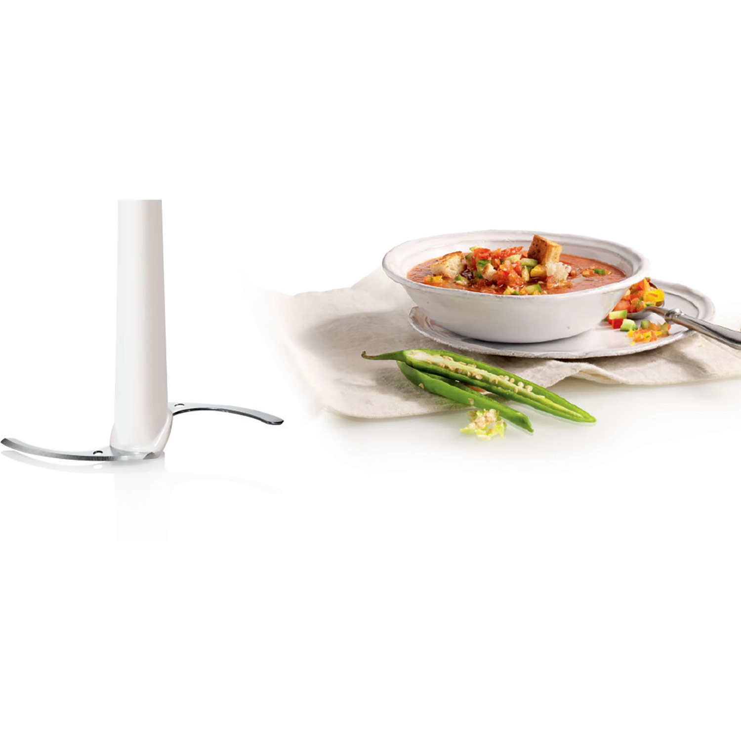 Blender with a bowl of soup and a plate with salsa. Green chili peppers are present.