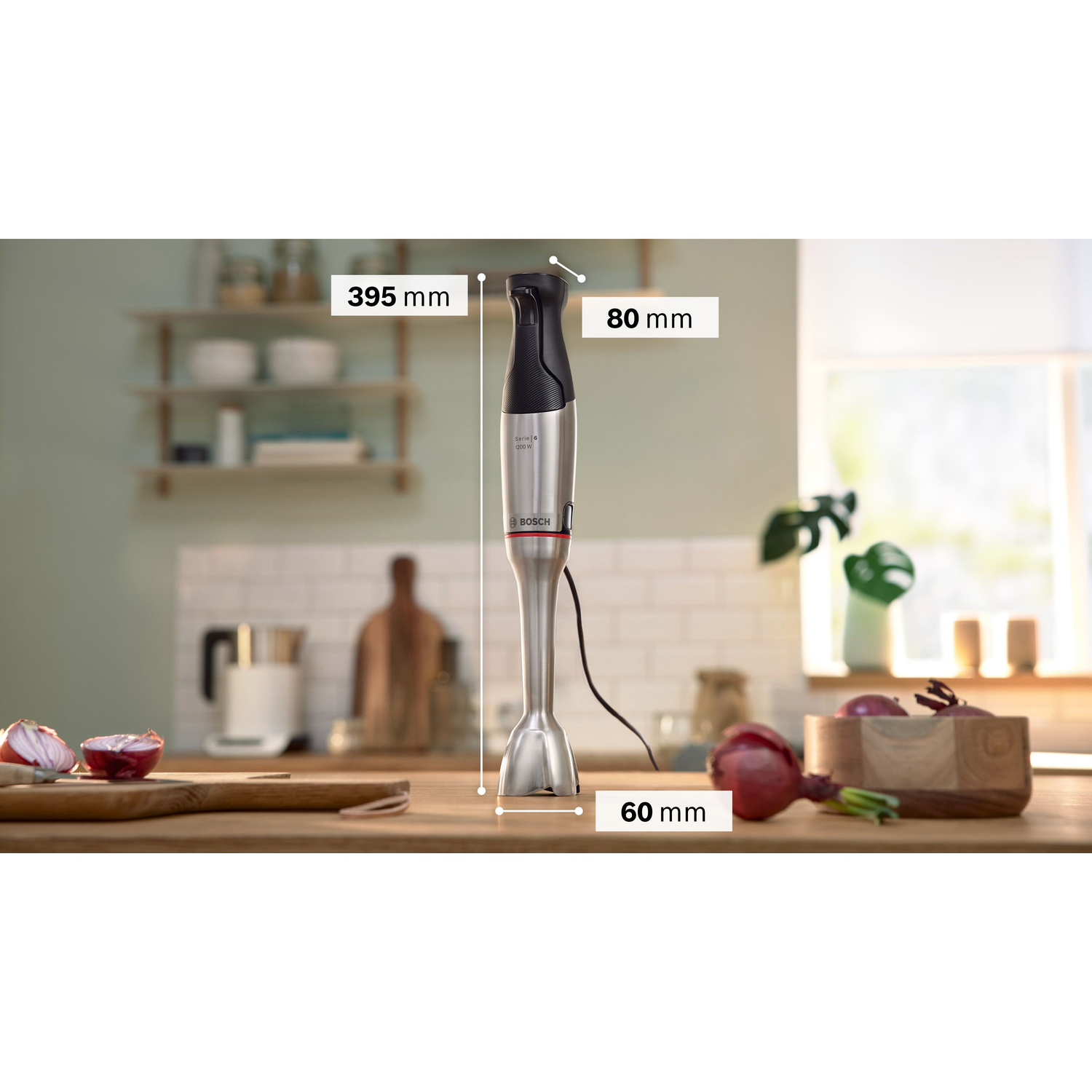 Hand blender with measurements. Red onions in a wooden bowl. Kitchen background.