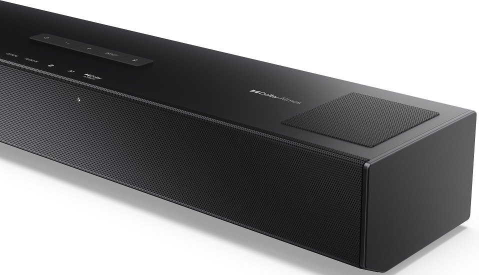 Egy fekete soundbar szövetráccsal és vezérlőgombokkal. A Dolby Atmos logó látható.