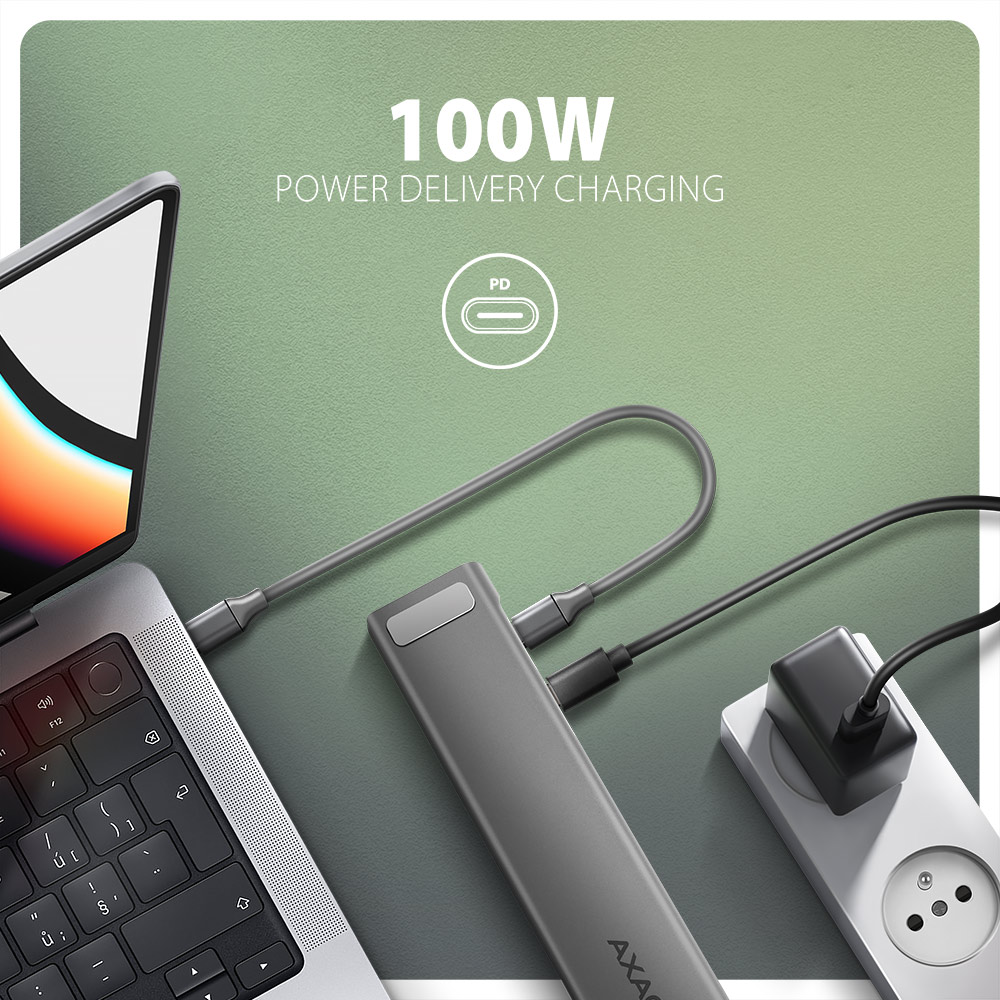 Laptop csatlakoztatva egy töltőhöz, 100W-os energiaellátást mutatva.