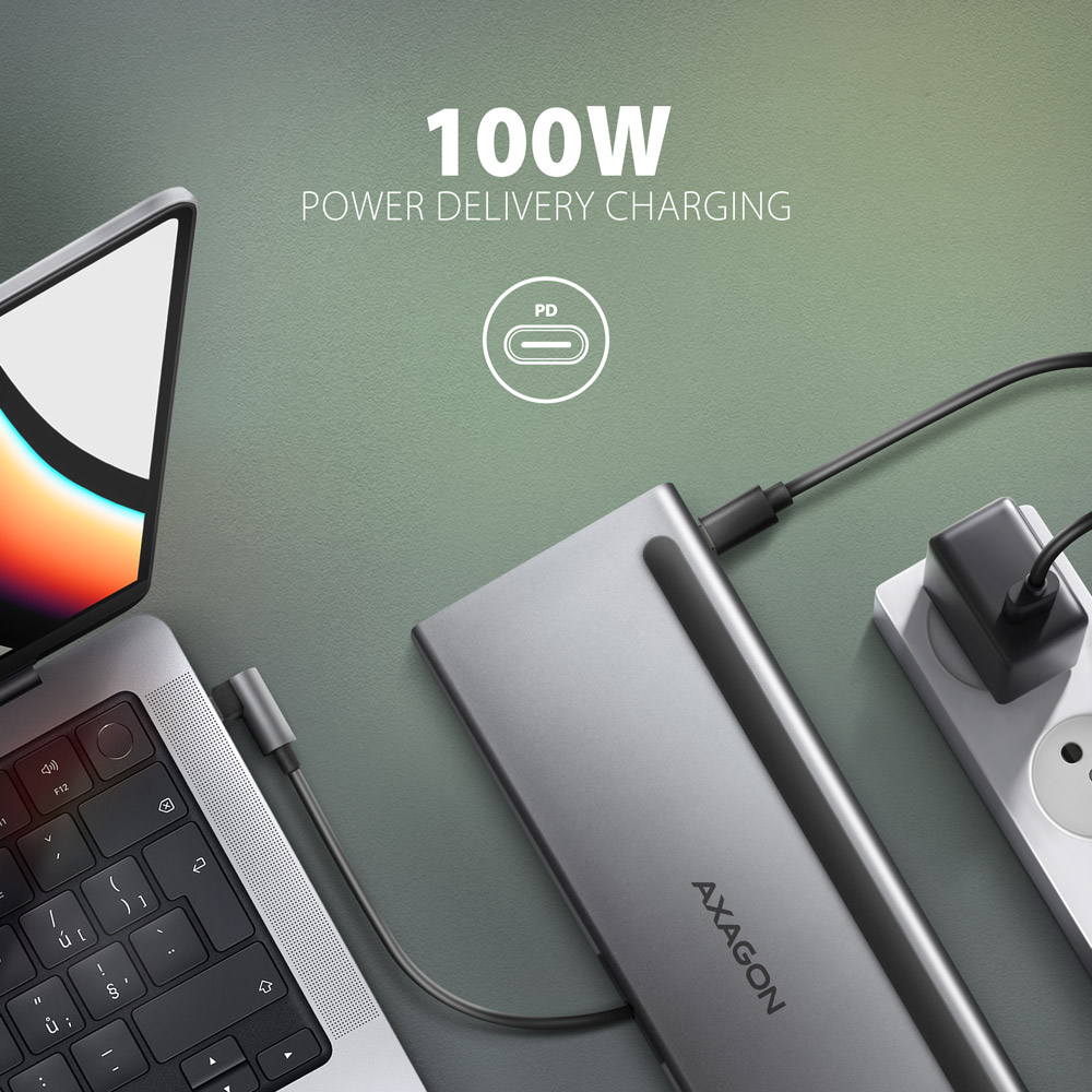 Laptop töltődokkolóhoz és konnektorhoz csatlakoztatva, '100W Power Delivery' felirattal.