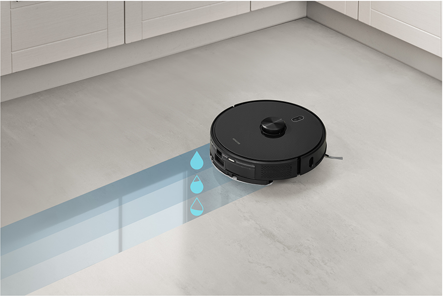 Fekete robotporszívó, szürke padlót takarít.