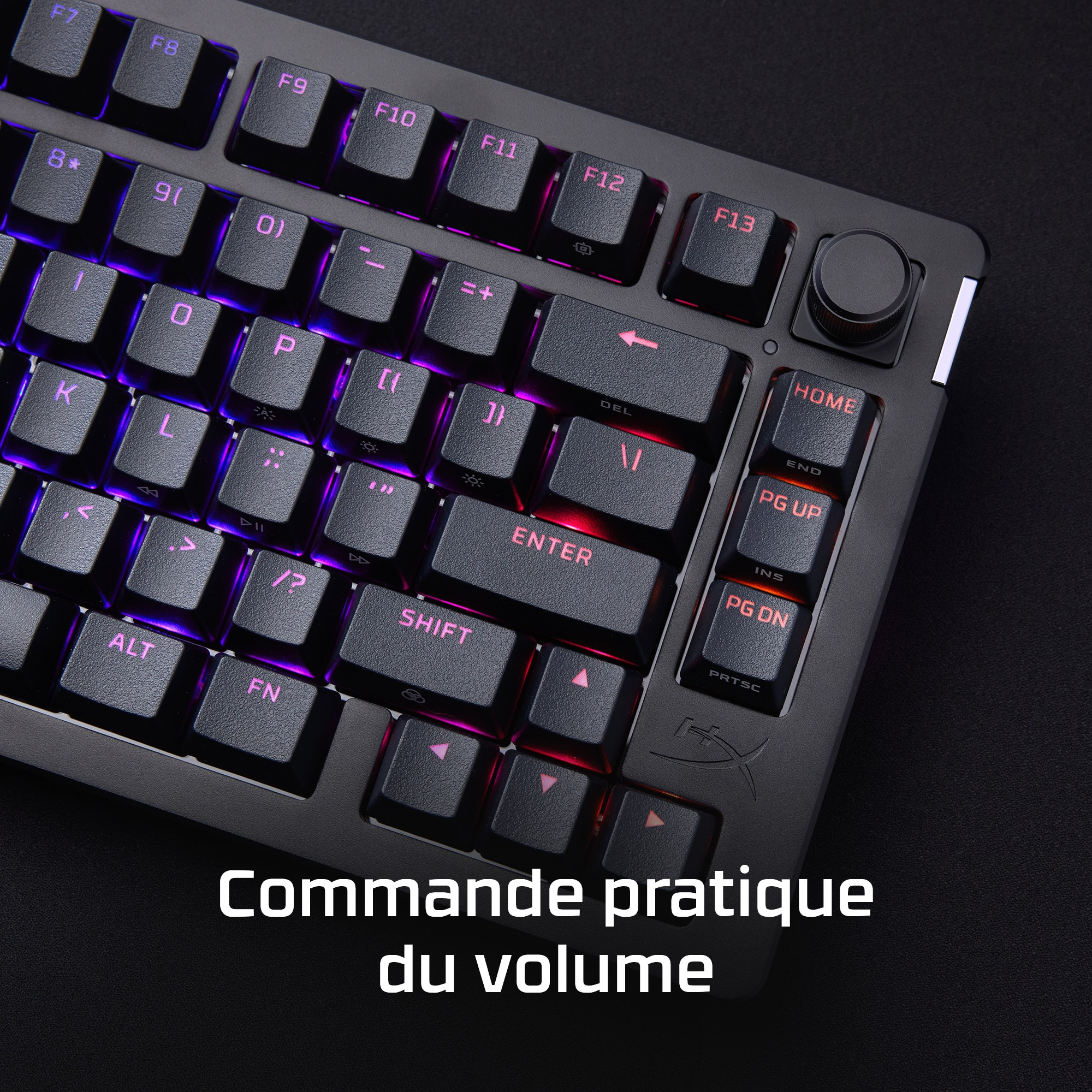Close up of a black keyboard with lit up keys and a volume control.