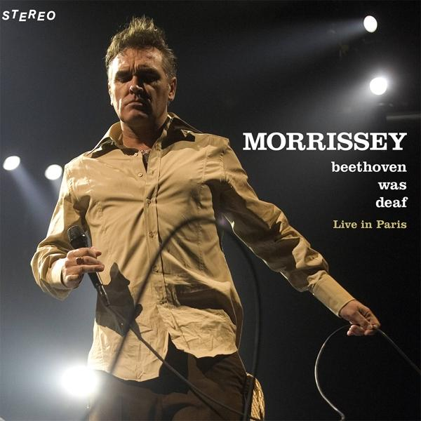 Live-Konzertfoto von Morrissey auf der Bühne, der ein Mikrofon hält. Text: Morrissey, Beethoven war taub.