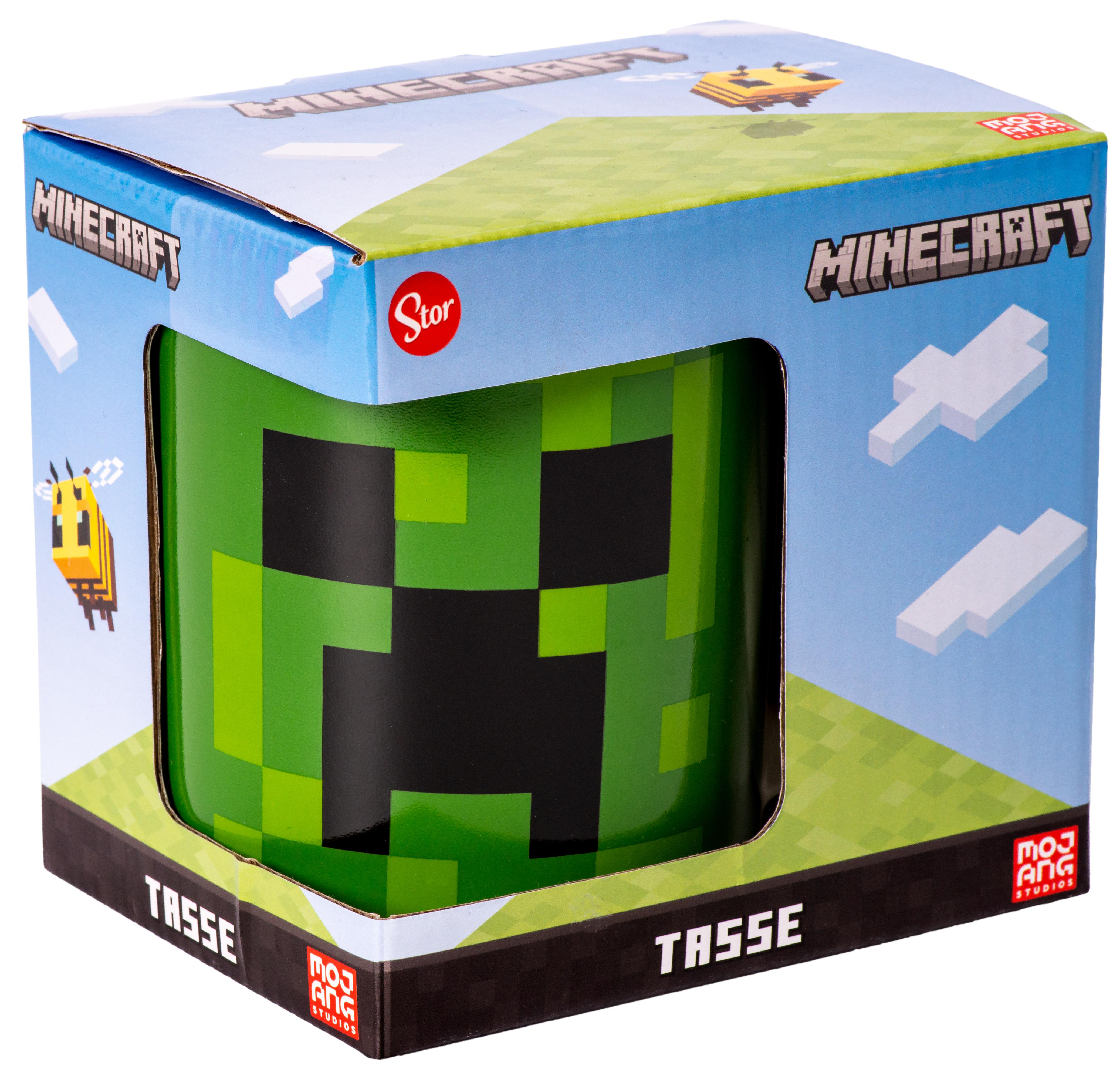 Minecraft Creeper-Tasse in der Box. Box hat Minecraft-Logo und Bilder. Tasse hat grünes Pixelgesicht.