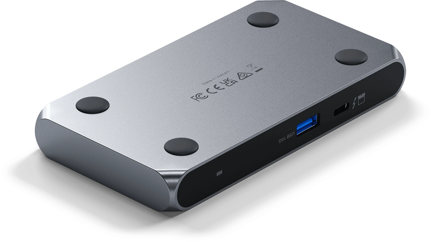 Ezüst USB hub négy gumi lábbal és USB porttal. Több port látható az oldalon.