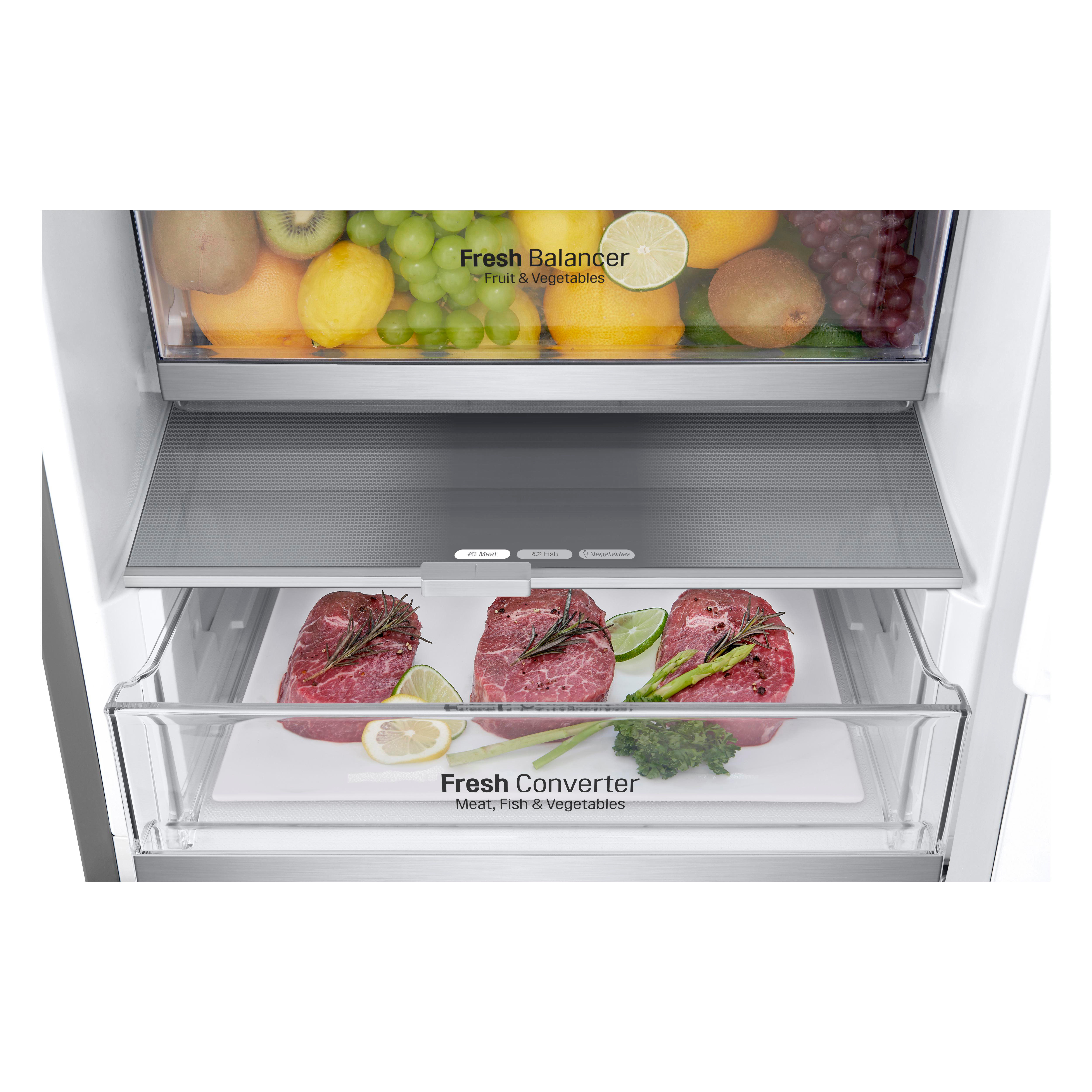 Kühlschrankinnenraum mit frischen Produkten. Fleisch, Obst und Gemüse in separaten Fächern.