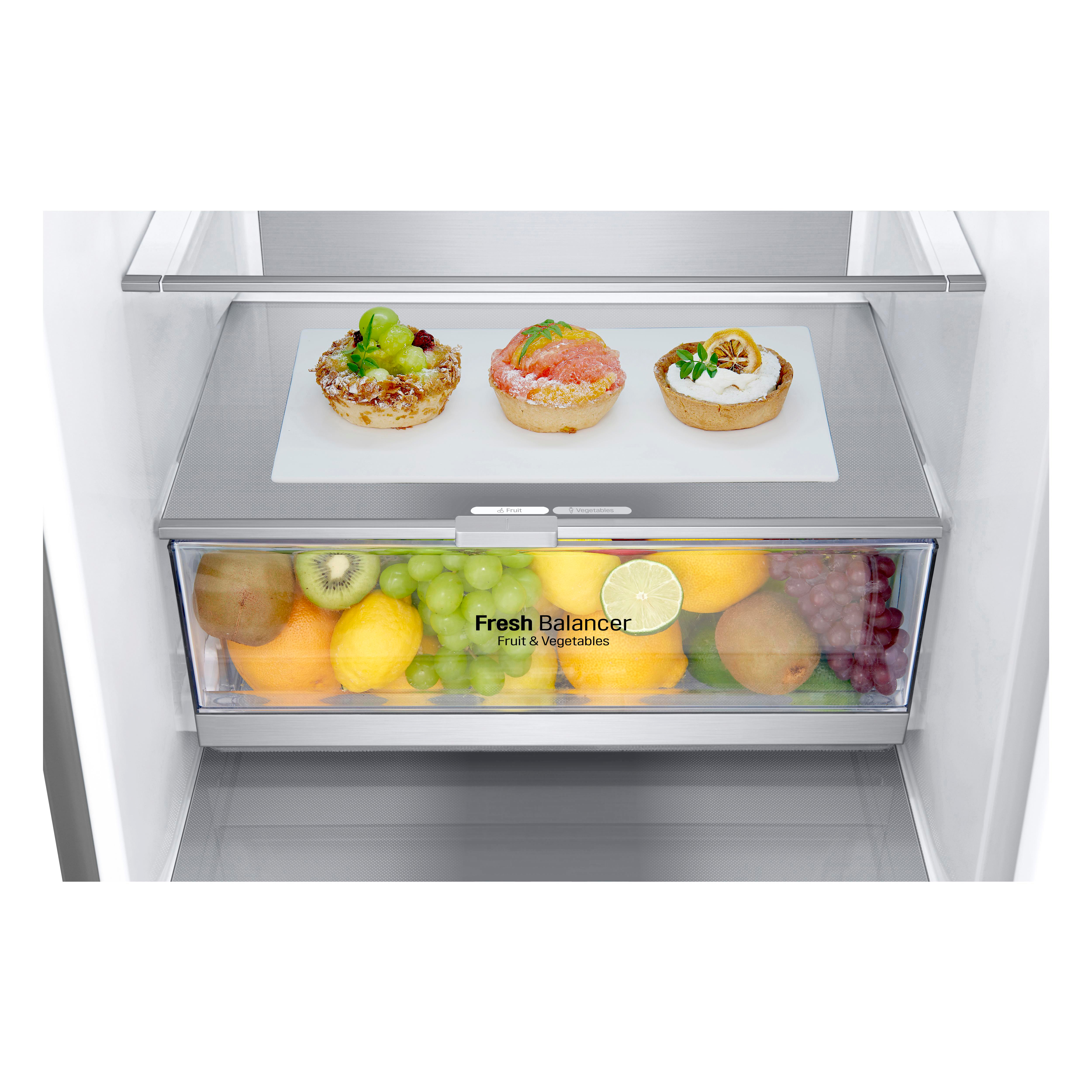 In einem Kühlschrank mit einer Obst- und Gemüseschublade und Gebäck auf einem Regal.