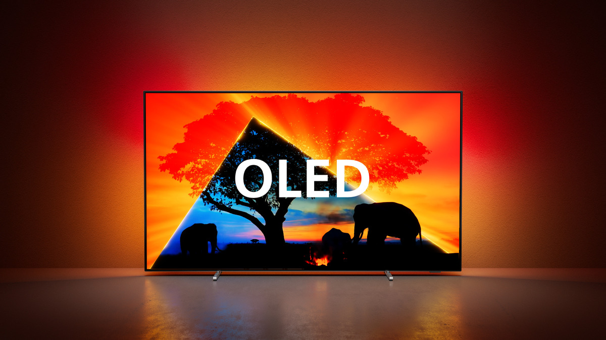 TV OLED che mostra un paesaggio con alberi ed elefanti con sfondo rosso e arancione.