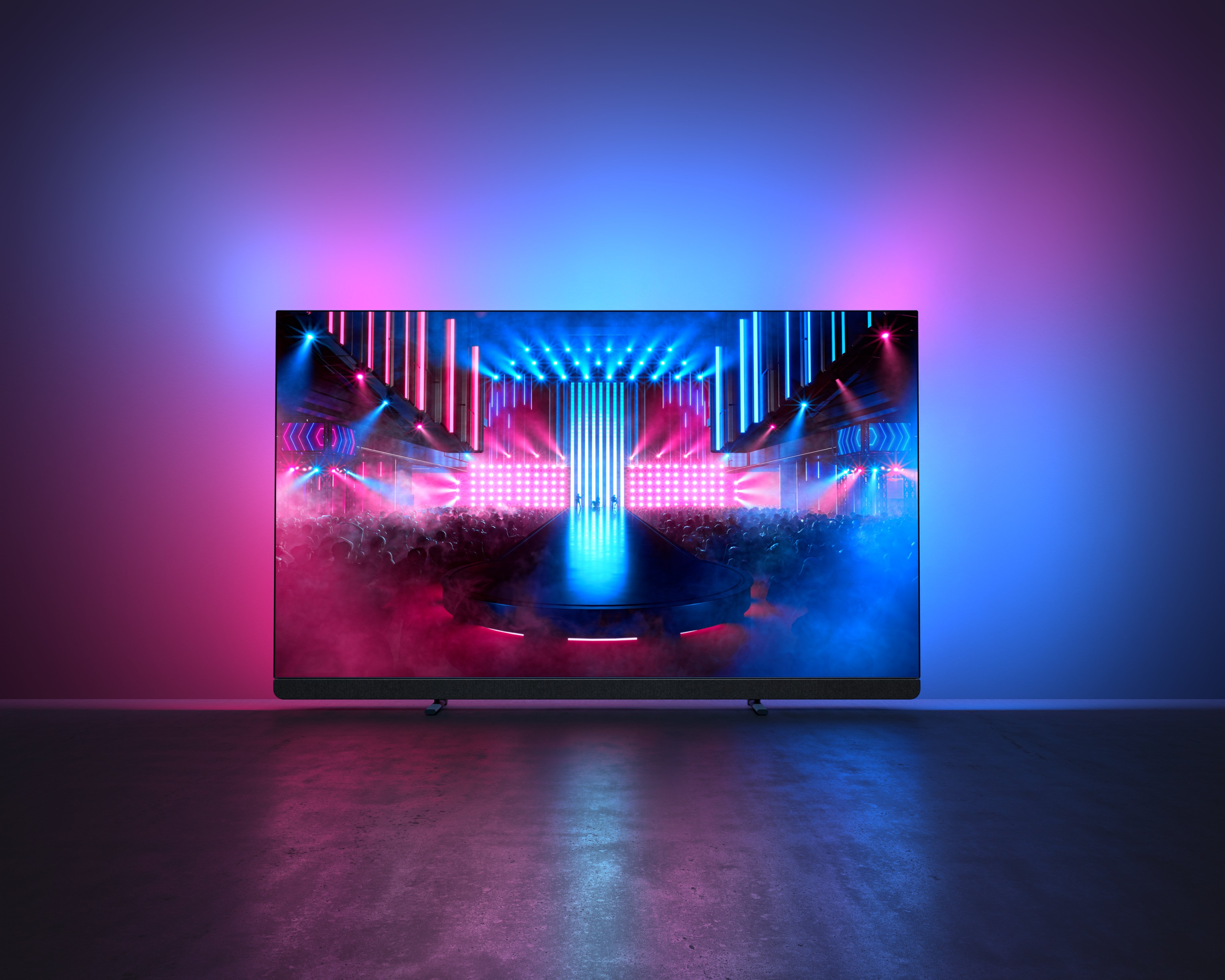 TV a grande schermo che mostra un palco con uno spettacolo di luci colorato.
