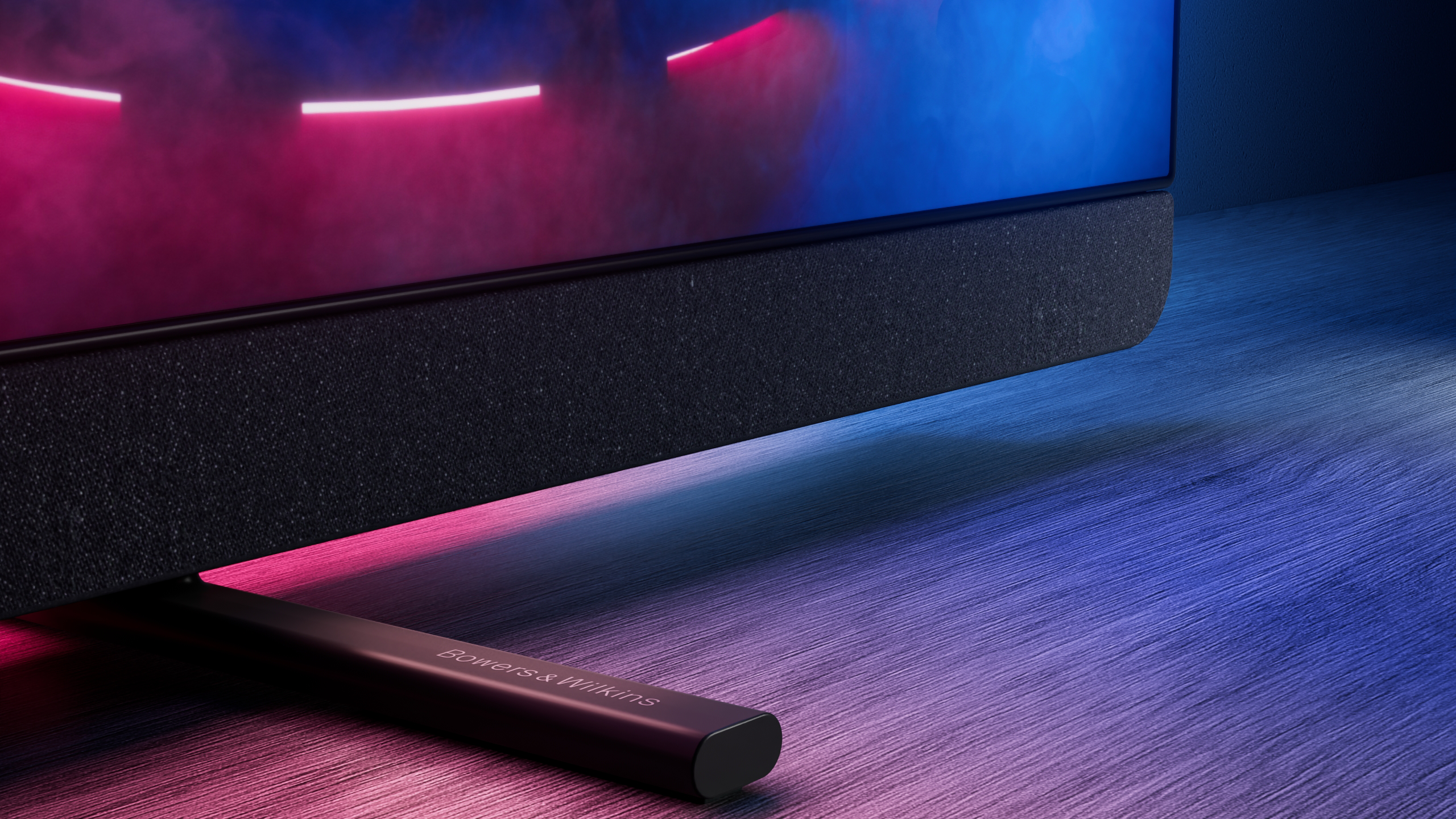 Primo piano della base della TV. Base TV nera con logo Bowers & Wilkins. Illuminazione RGB.