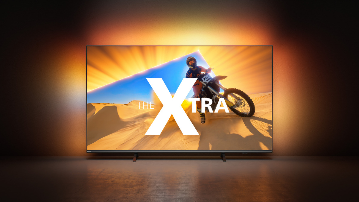 Großer TV-Bildschirm, der eine Person zeigt, die Motorrad in der Wüste fährt.