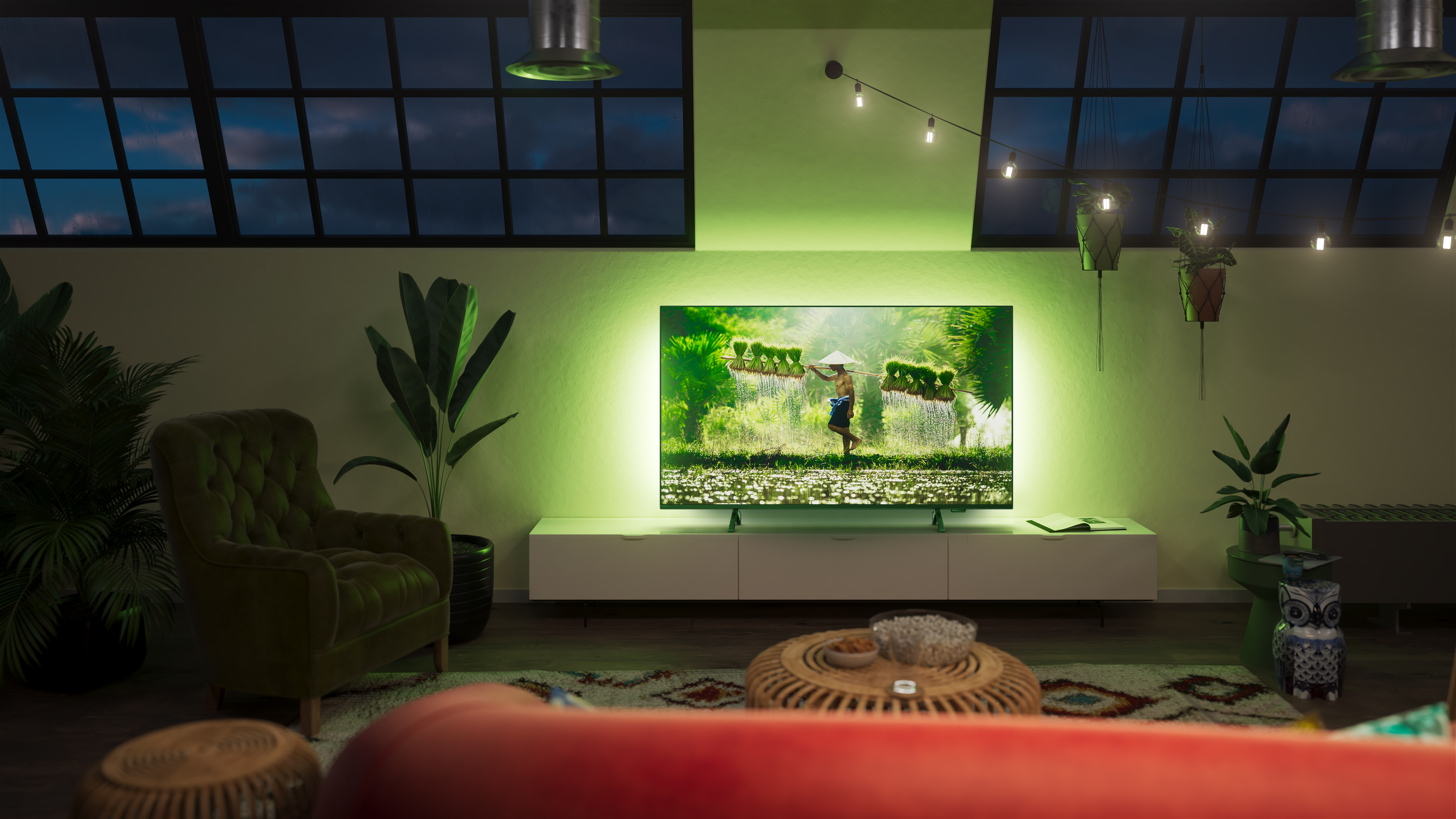 Soggiorno con TV, illuminazione ambientale verde e arredo accogliente.