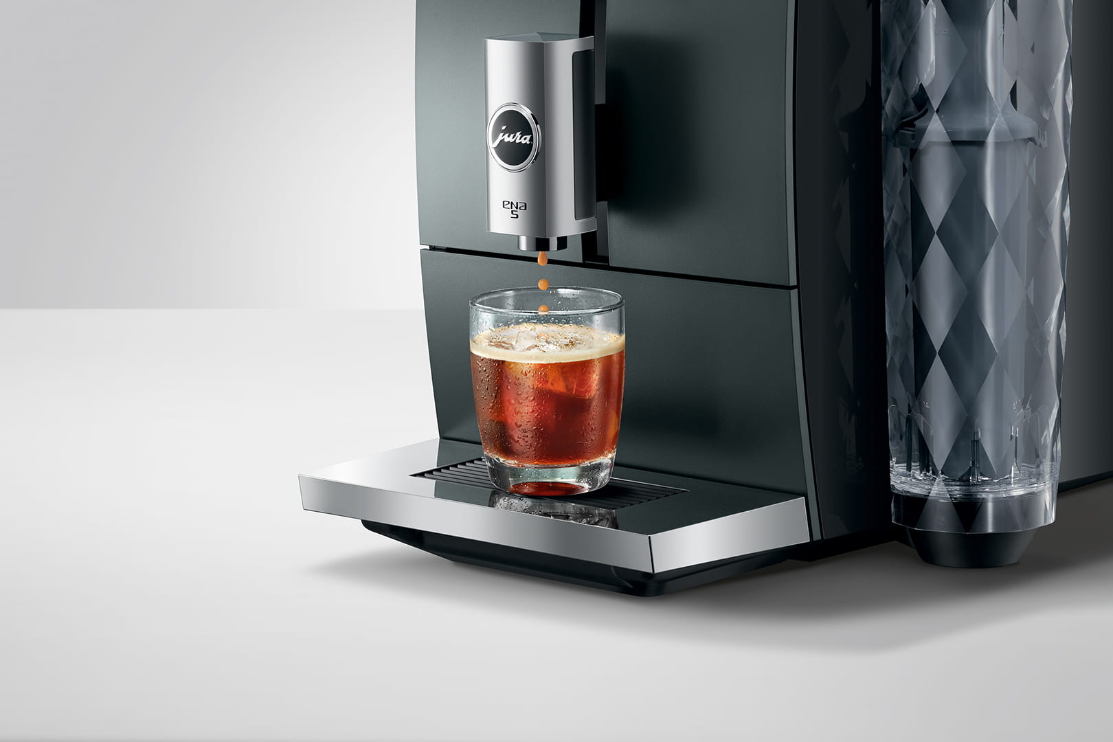 Macchina da caffè che eroga caffè in un bicchiere con ghiaccio.