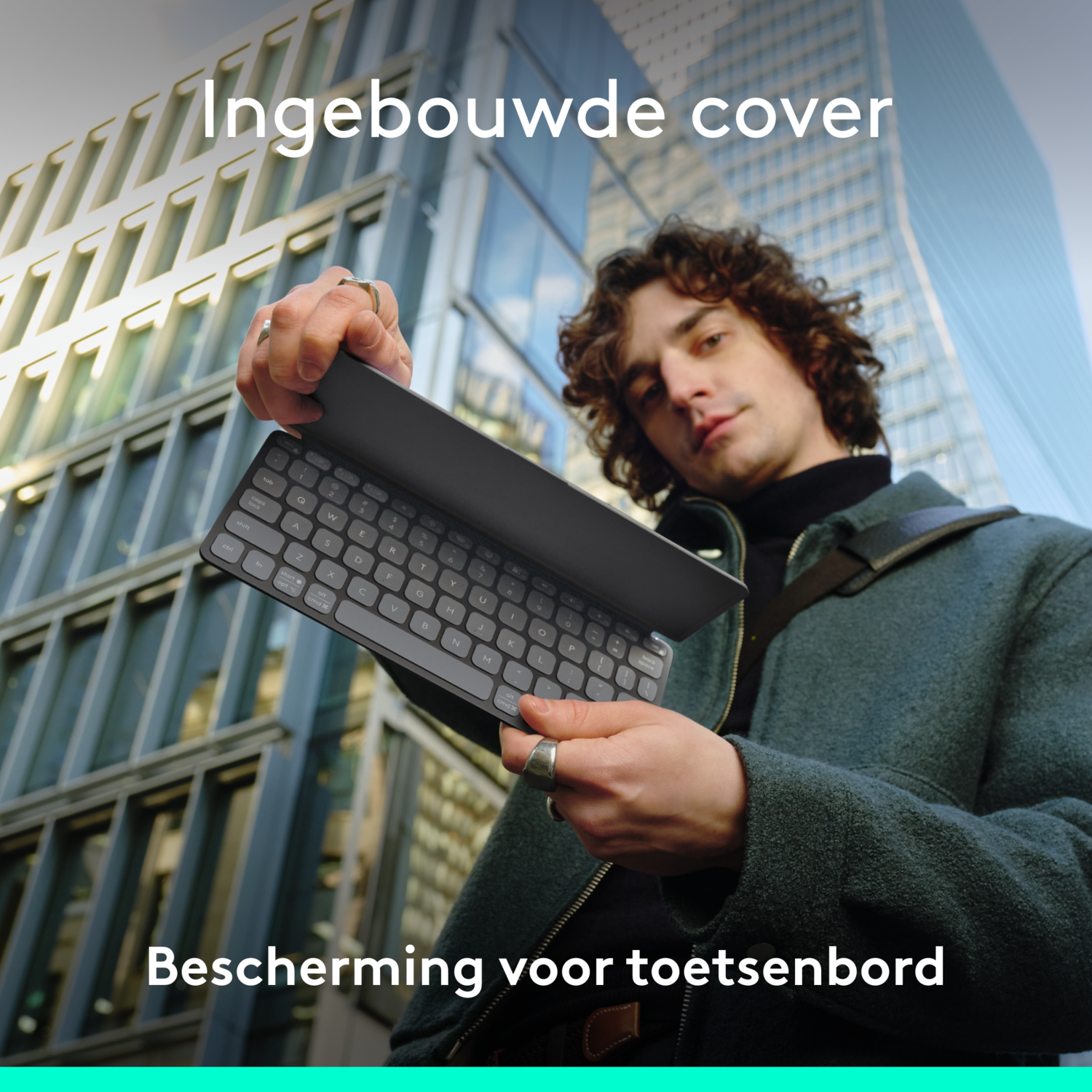 Man houdt een toetsenbord met hoes vast. Modern gebouw zichtbaar op de achtergrond.
