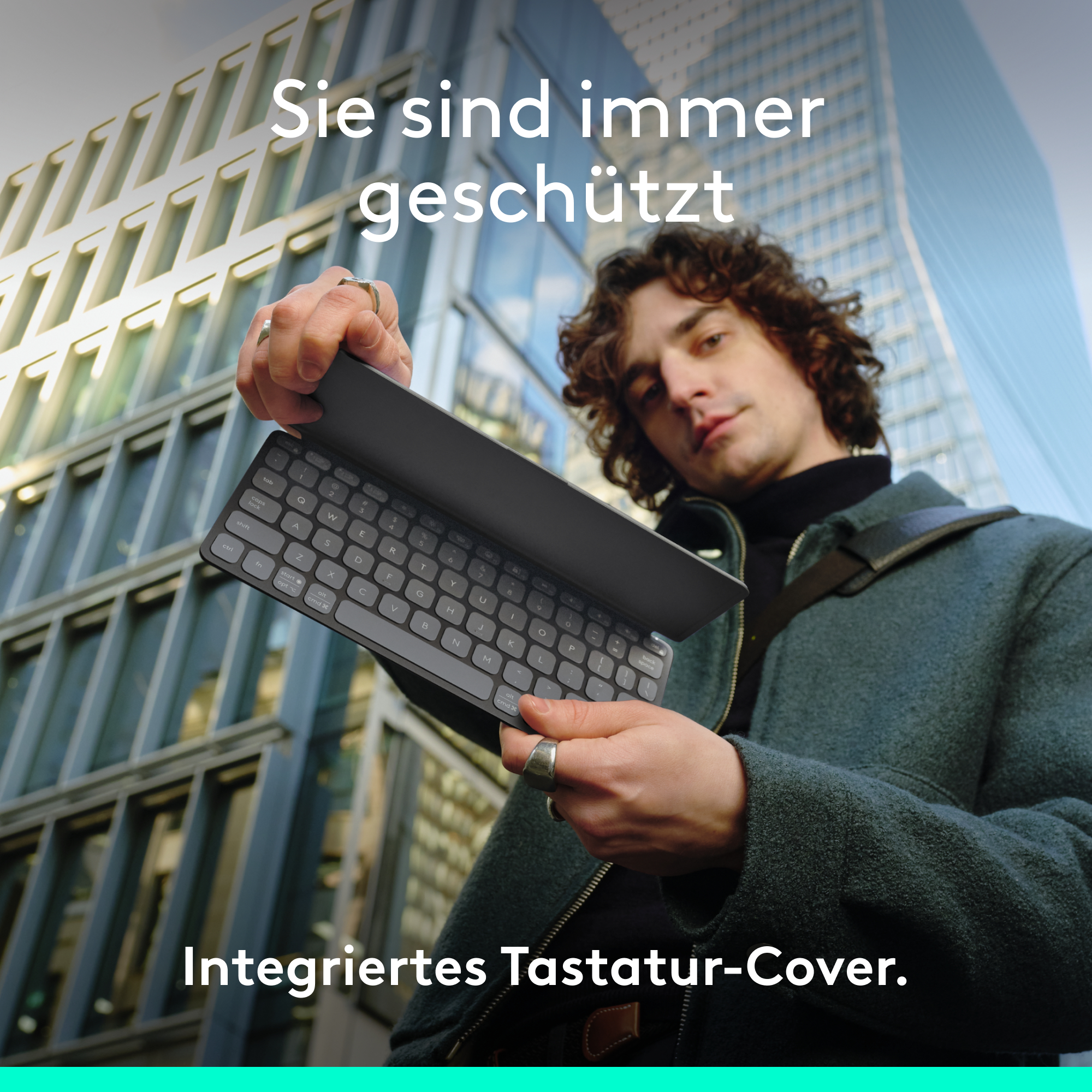 Ein Mann hält eine schwarze Tastatur vor einem modernen Gebäude. Text sagt 'Sie sind immer geschützt'.