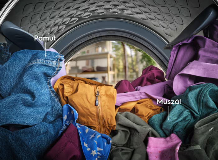 Mosogatógép belseje tiszta fehér edényekkel, csészékkel és különböző eszközökkel.