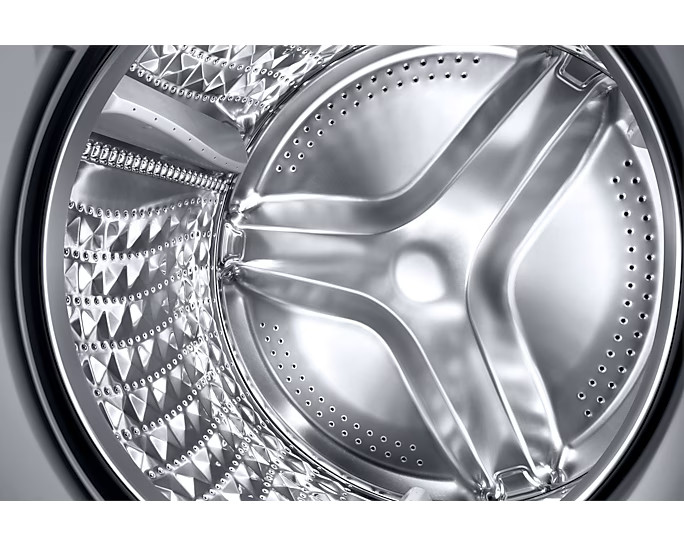 Zbliżenie bębna pralki, błyszczące i metaliczne.