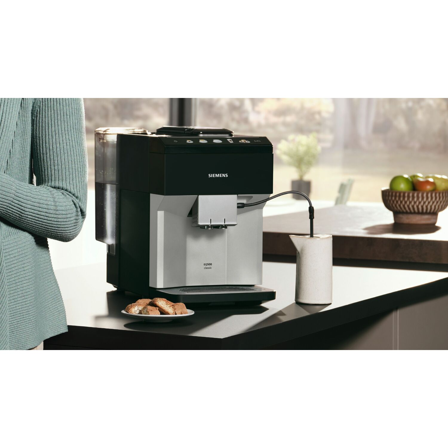 Une machine à café avec une carafe et des biscuits sur une table.