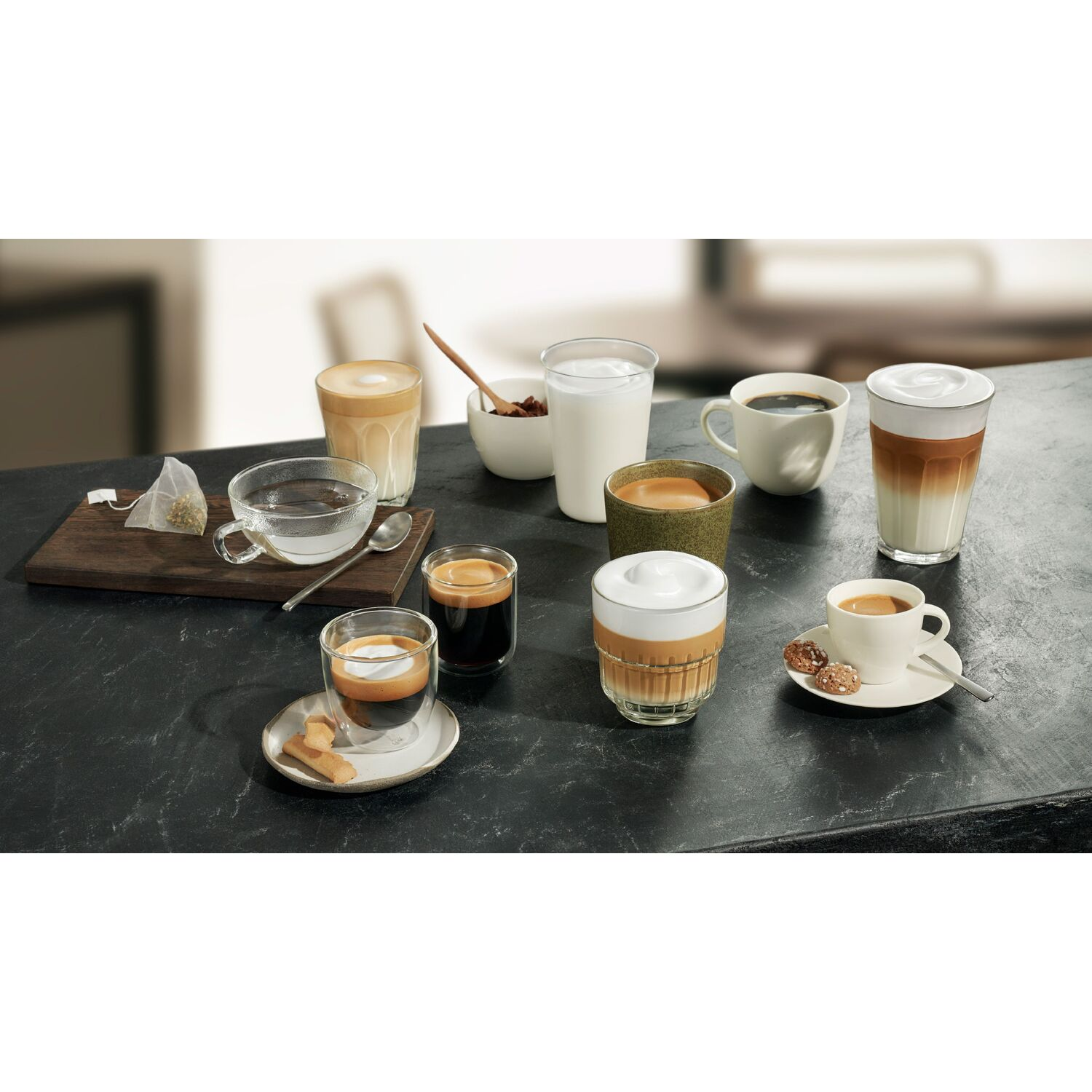 Diverses boissons au café et une tasse de thé sur une surface sombre.