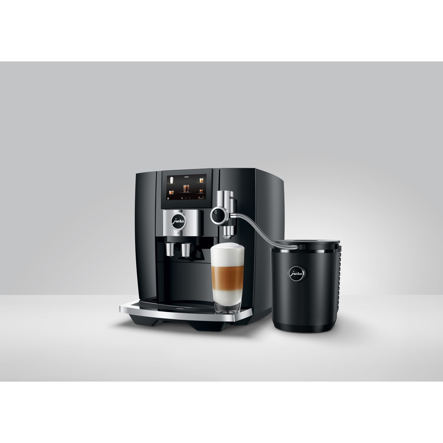 Black coffee machine with glass of latte and milk container.