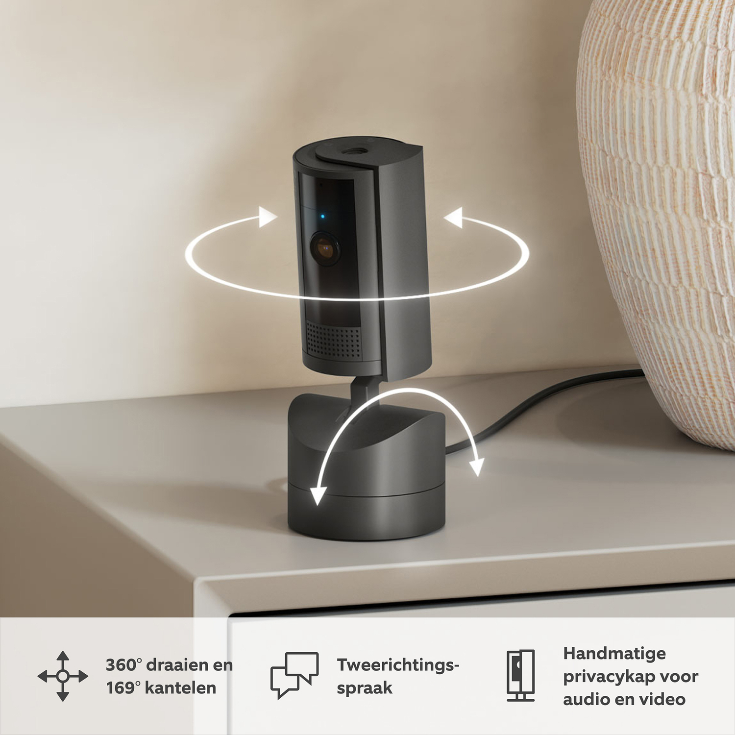 Black security camera on a white surface. Gray vase in the background. Arrows indicate rotation and tilt.