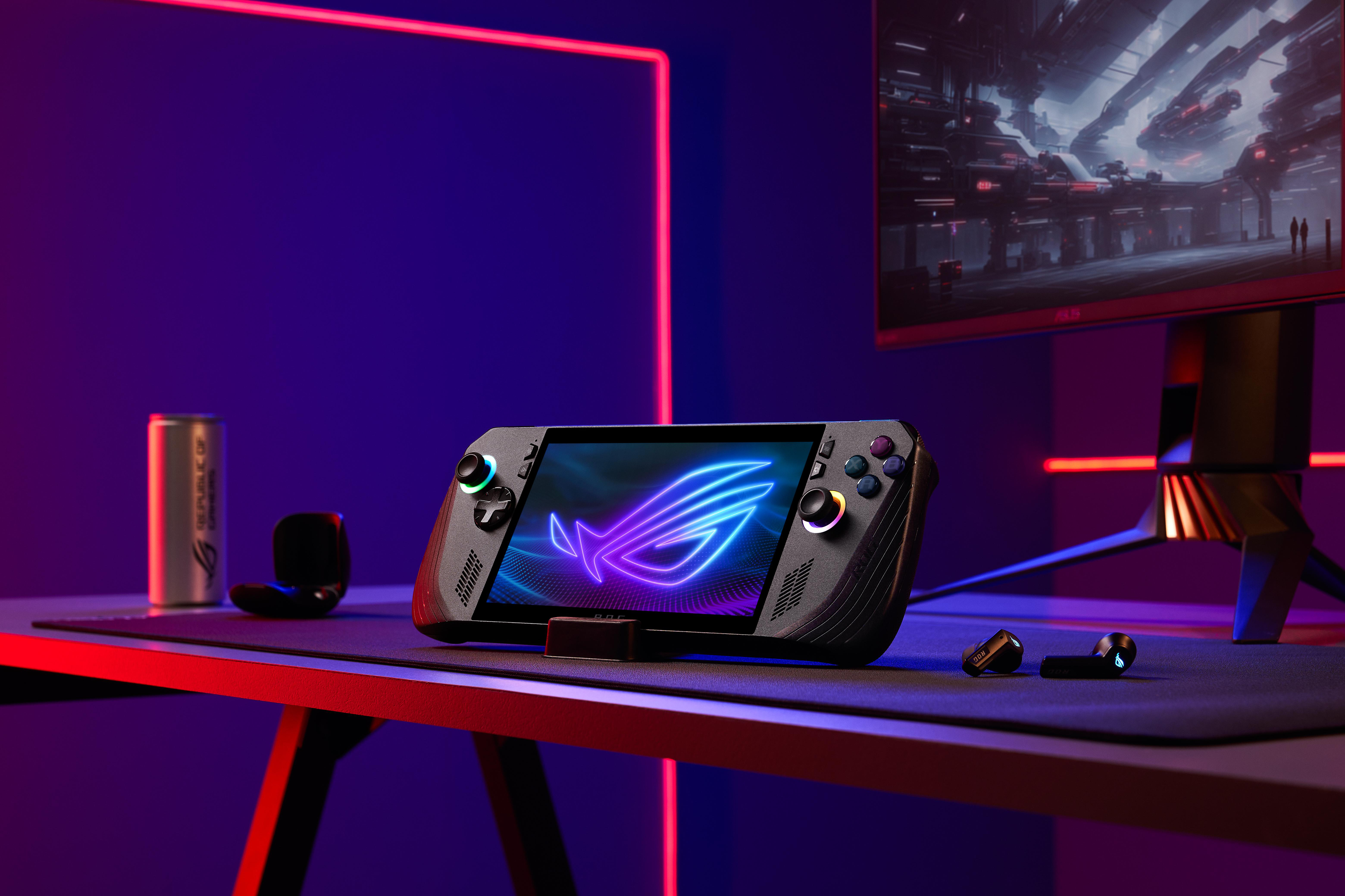 Ein Gaming-Handheld-Gerät auf einem Schreibtisch mit Monitor und Gaming-Zubehör.