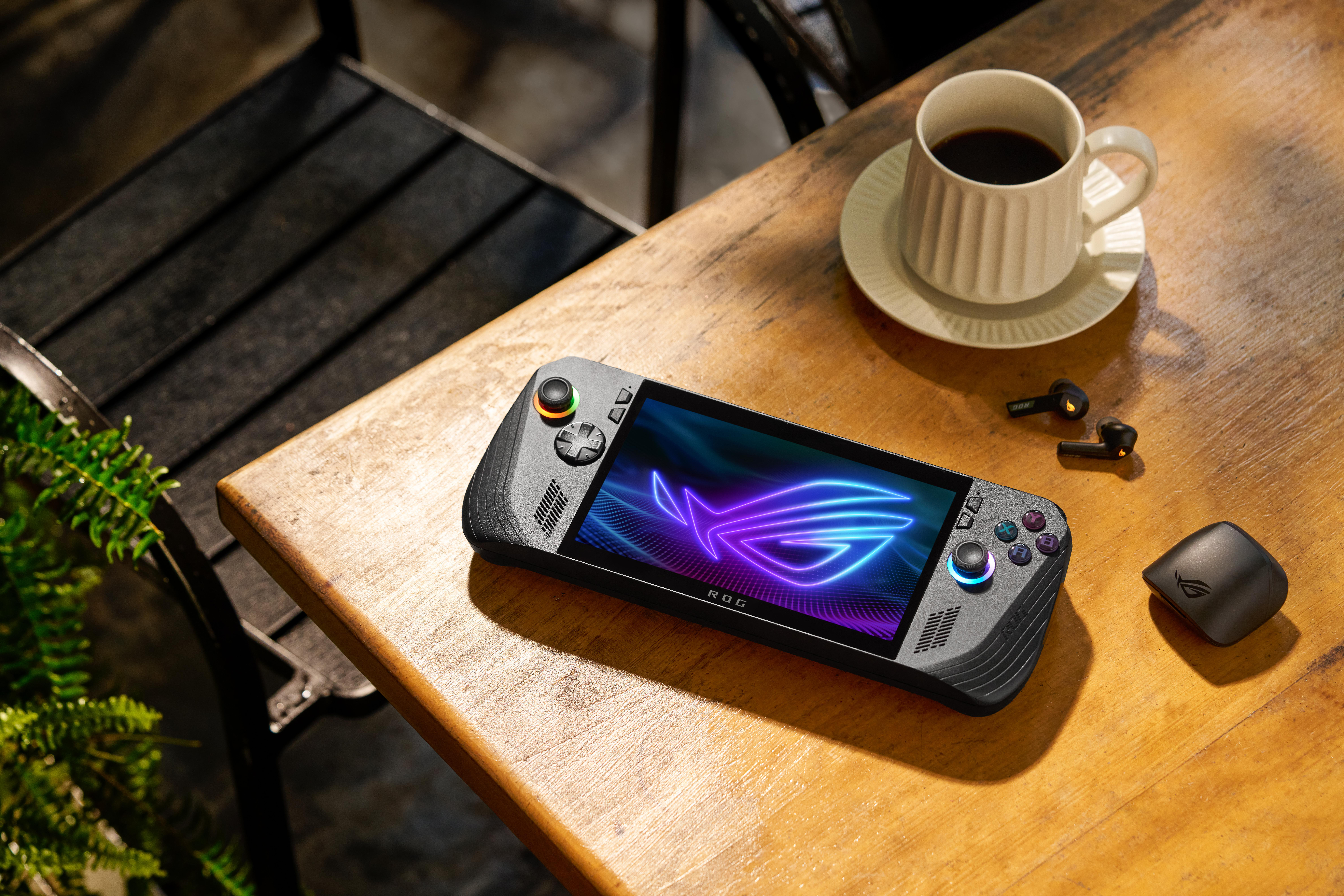 Ein Handheld-Gaming-Gerät mit beleuchtetem Bildschirm und Zubehör auf einem Holztisch.