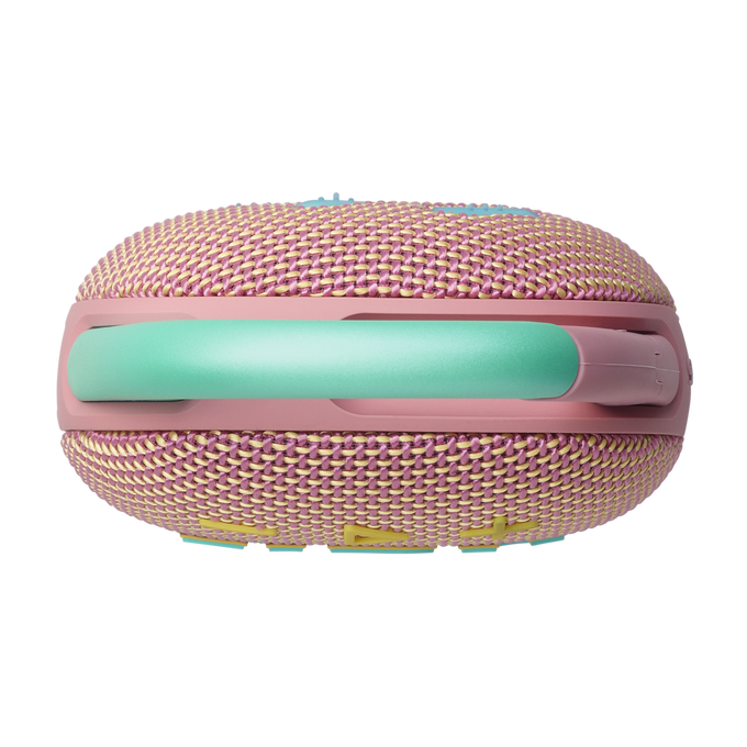 Un altavoz portátil rosa y amarillo con un asa verde sobre un fondo negro. Foto de producto aislado.
