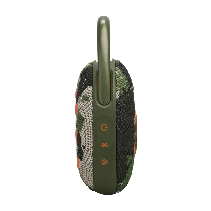 Altavoz camuflaje con clip verde, botones y funda de tela, vista lateral sobre negro.