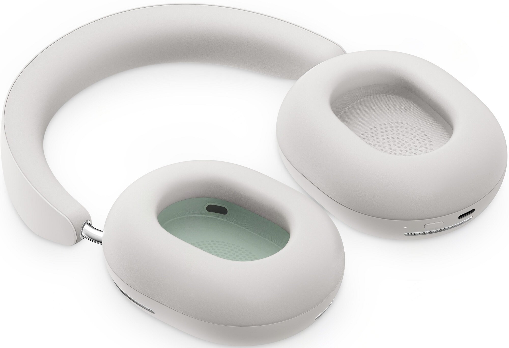 Białe słuchawki z jasnozielonymi wewnętrznymi nausznikami, na białej powierzchni.