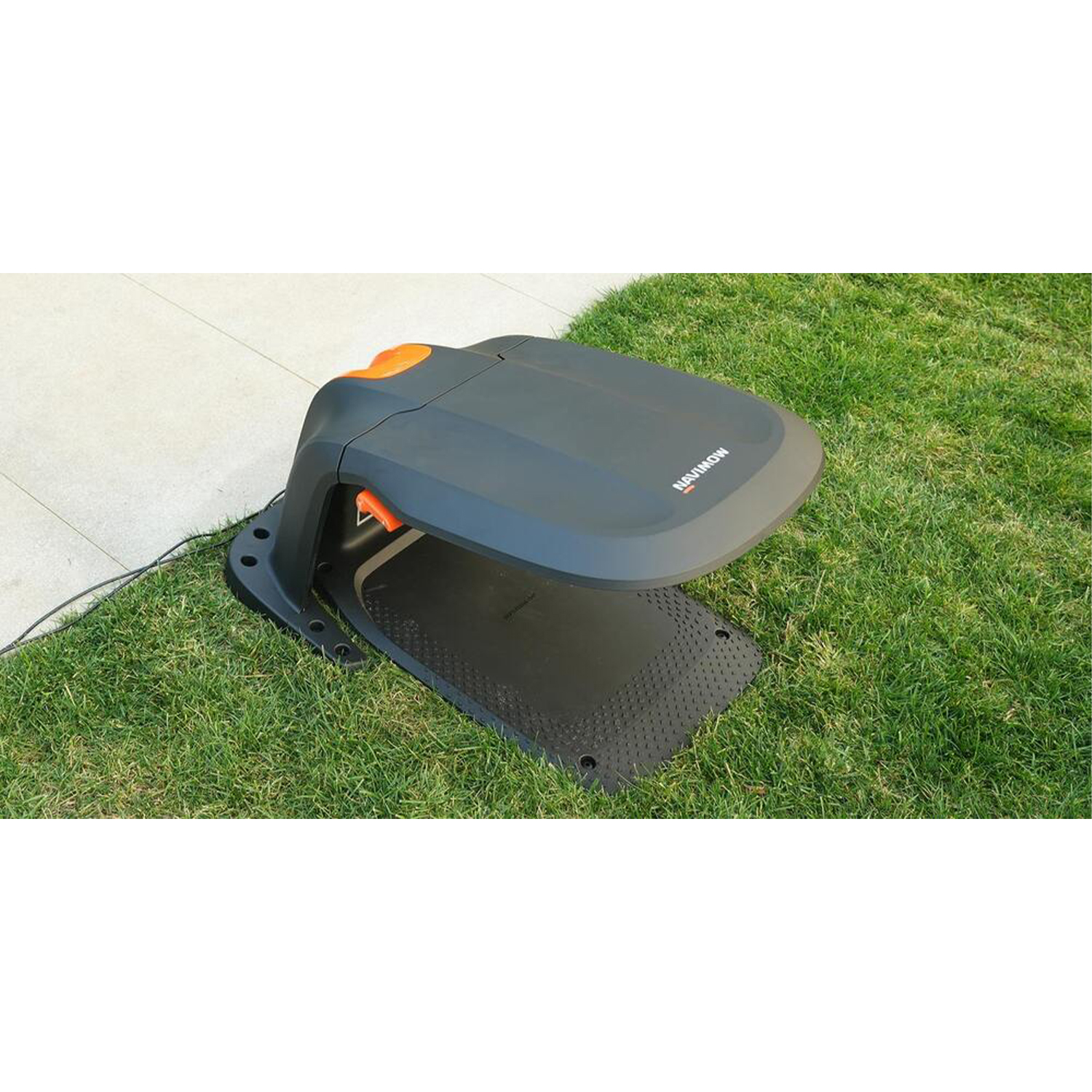 Robot tosaerba su erba verde. Ha un top arancione e una base nera.