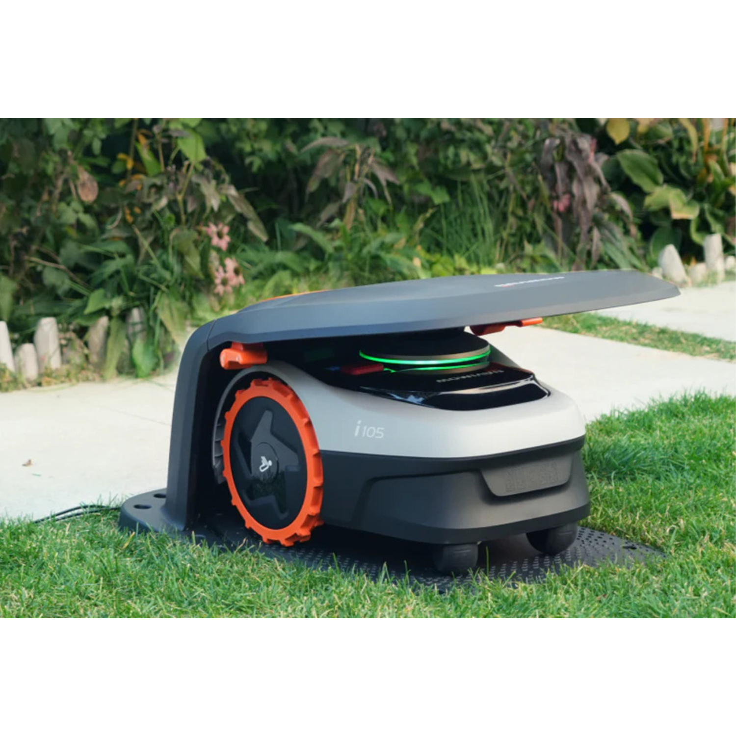 Tosaerba robotico sull'erba, con base nera e ruote arancioni, coperchio aperto.