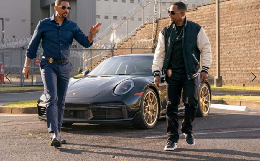 Will Smith und Martin Lawrence gehen auf einen schwarzen Porsche zu.