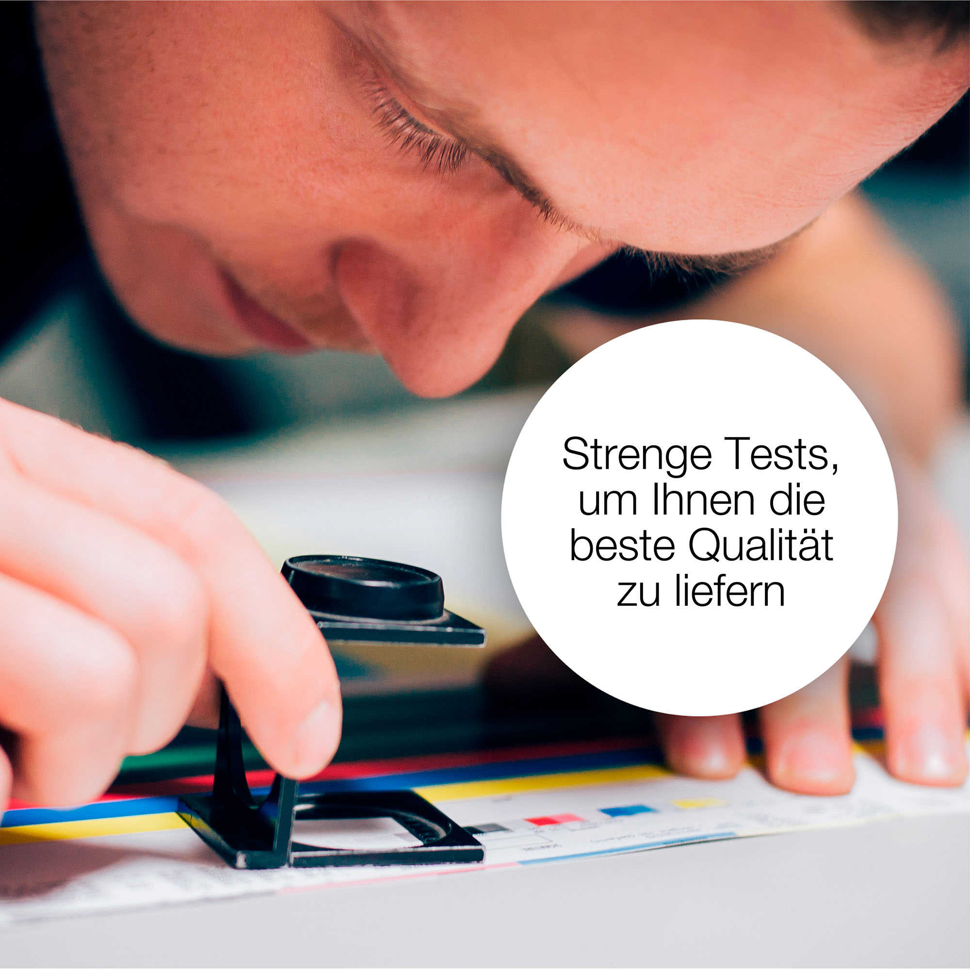 Eine Person untersucht mit einer Lupe ein mehrfarbiges gedrucktes Dokument.