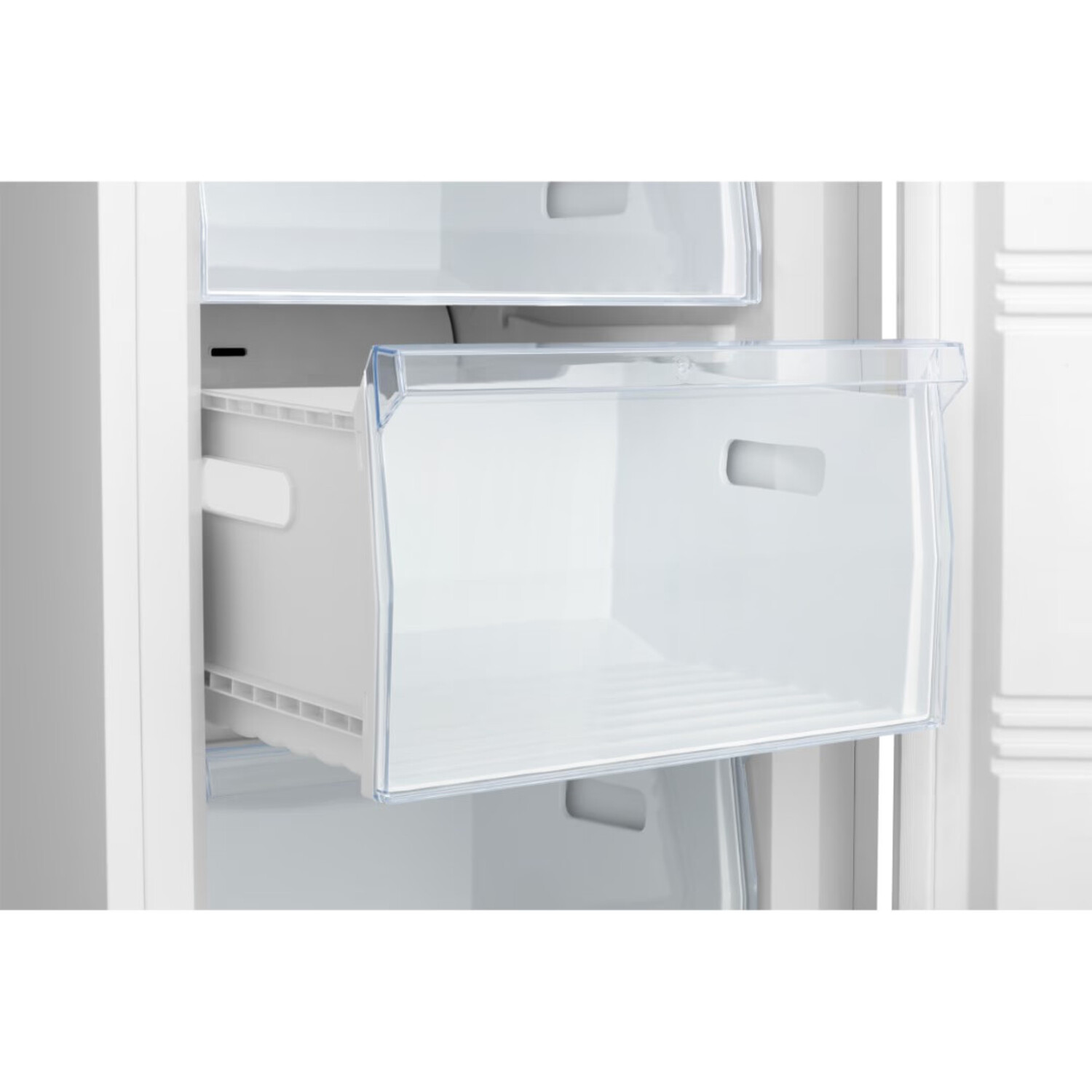 An open white freezer drawer with a clear plastic front, inside a white refrigerator.