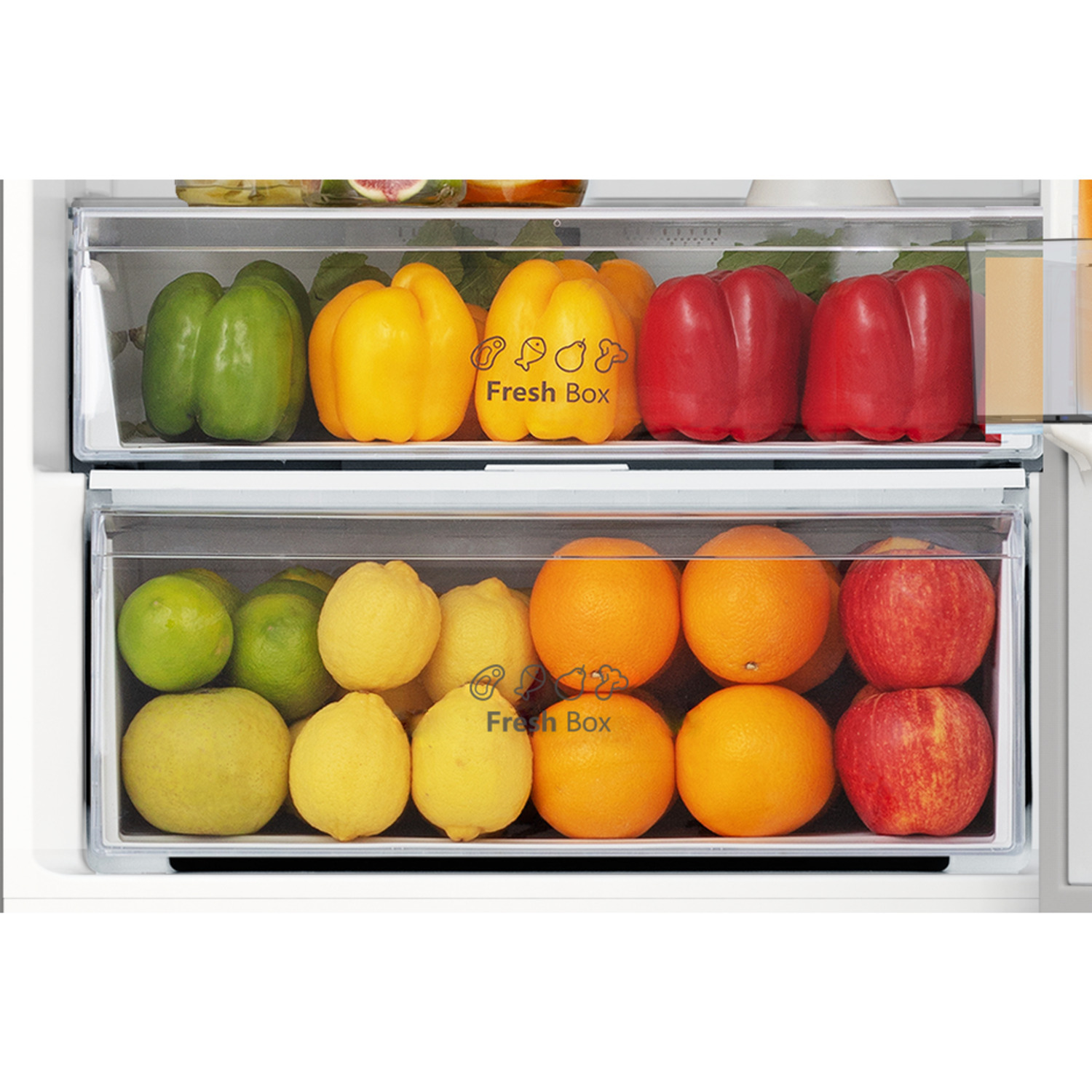 Intérieur de réfrigérateur avec poivrons, oranges, pommes et citrons dans des tiroirs transparents.
