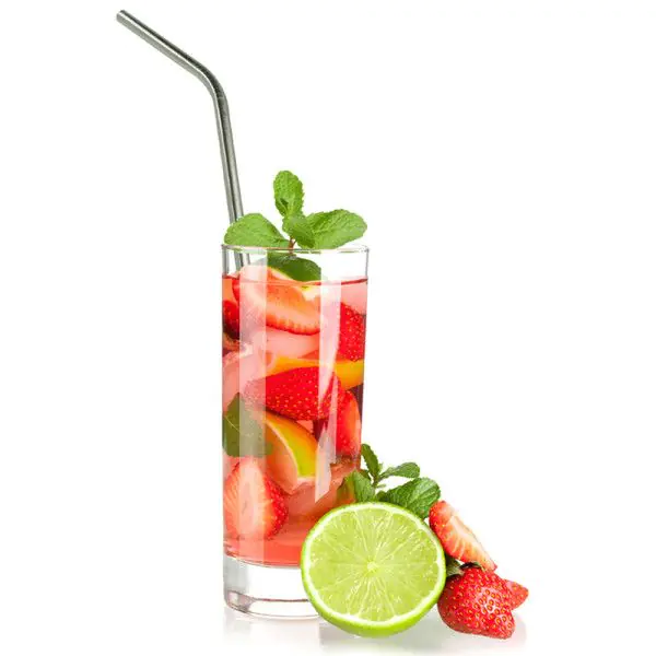 Vaso de bebida rosa con fresas, menta y lima. Pajita metálica en el vaso.