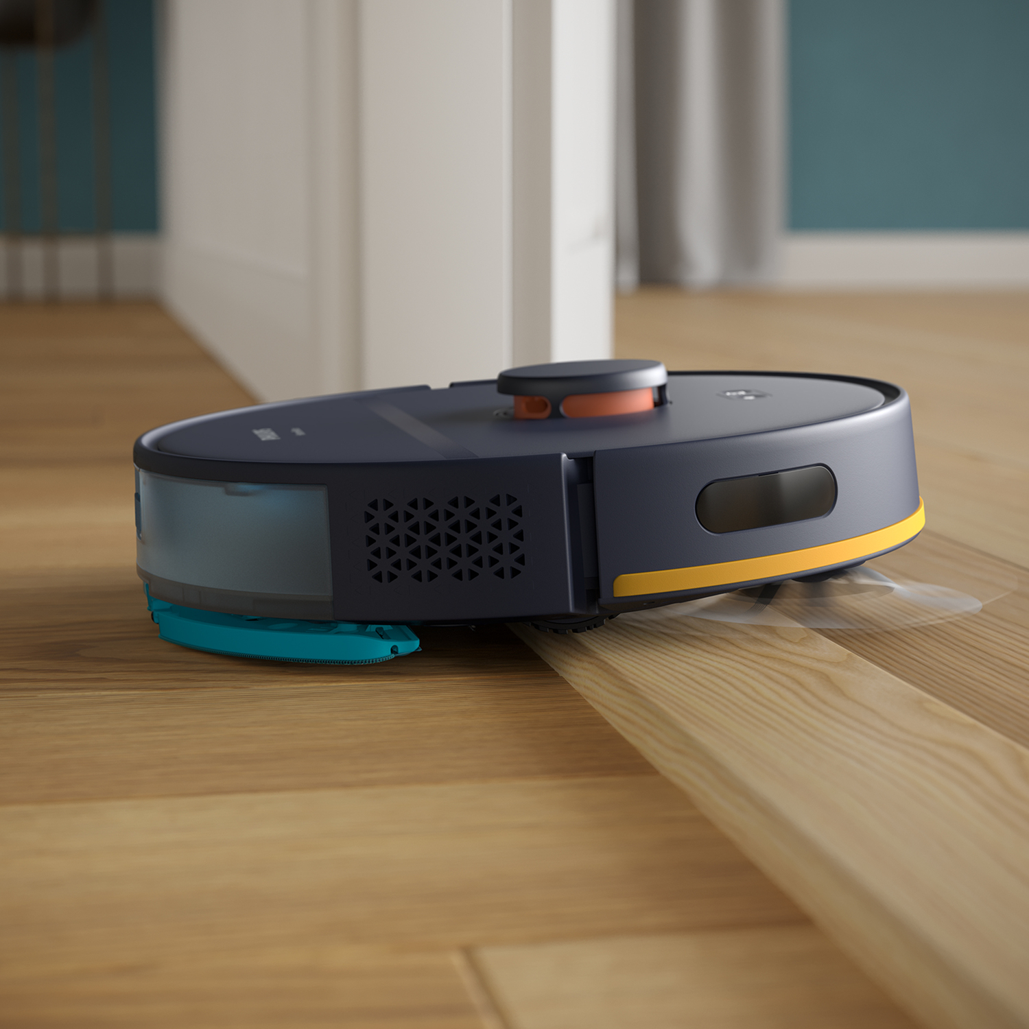 Aspirateur robot sur un sol en bois. Il est bleu foncé avec des accents orange et jaune. Une porte blanche en arrière-plan.