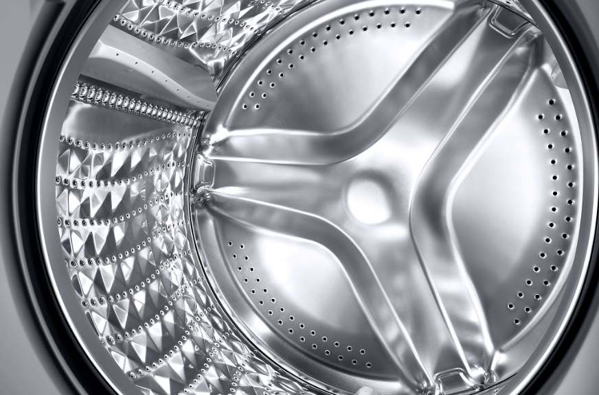 Wnętrze bębna pralki, srebrne, z otworami i centralnym krzyżem.