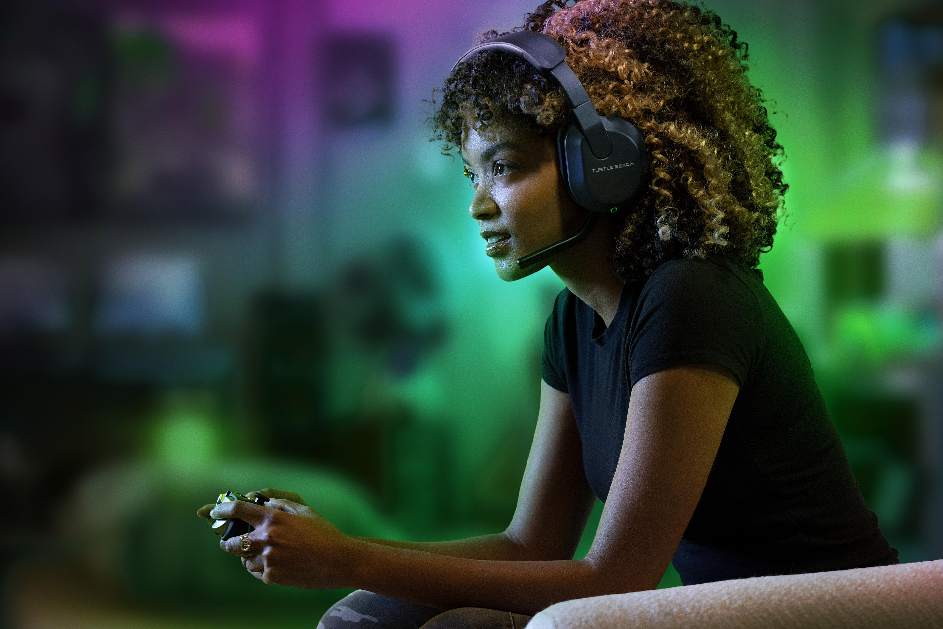 Eine Frau spielt ein Videospiel mit Headset und Controller.