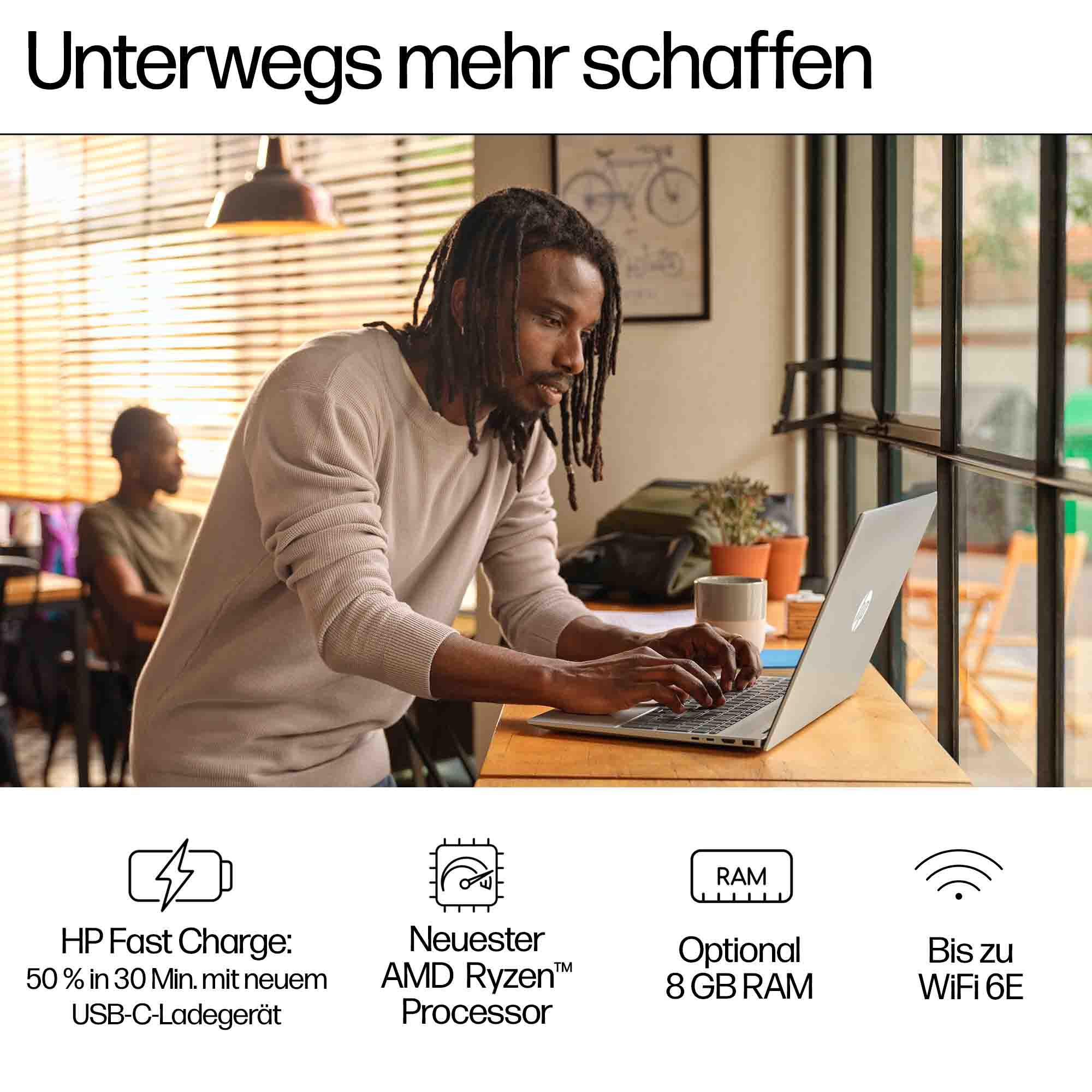 Ein Mann arbeitet an einem Laptop an einem Tisch mit Textfeldern unter dem Laptop.